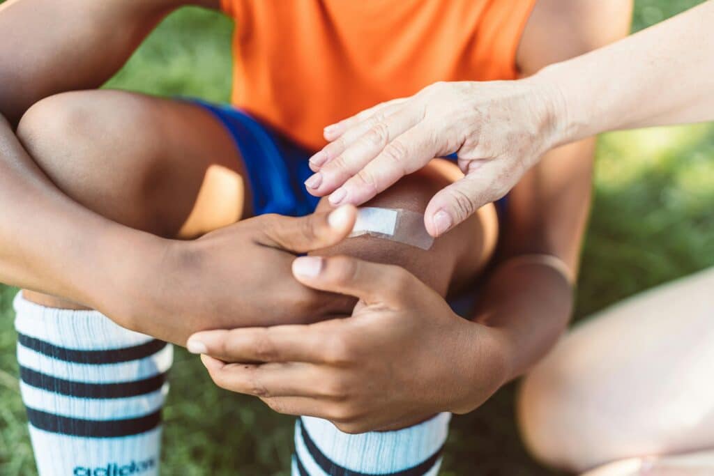 a person putting a bandage on a person's knee